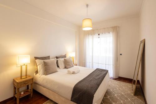 布拉加Braga 3BR Wonder by LovelyStay的卧室设有一张白色大床和一扇窗户。