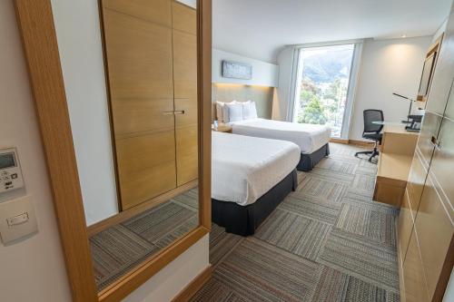 波哥大波哥大索内斯特酒店的酒店客房,设有两张床和镜子