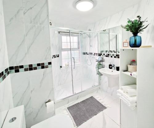 伦敦Charming room in Central London的带淋浴和盥洗盆的白色浴室