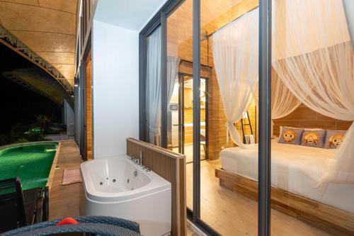 芭东海滩Three Monkeys Villas的带浴缸的浴室和1间带1张床的卧室