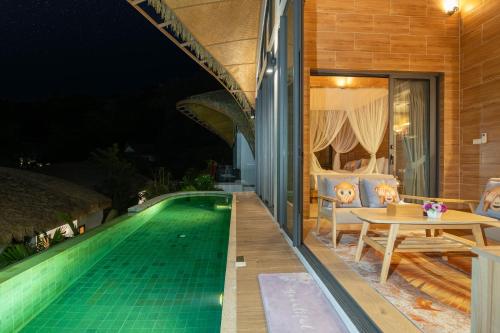 芭东海滩Three Monkeys Villas的一座晚上设有游泳池的房子