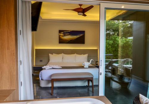 艾库玛尔Luxurious Apartments With BBQ Pool Garden Jungle View的一间卧室配有一张床和吊扇