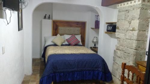 瓜纳华托Hotel Magdalena Colonial的一间卧室配有一张带蓝色棉被的床