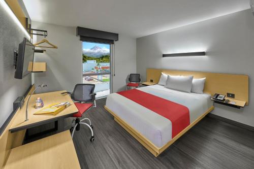 塔帕丘拉City Express by Marriott Tapachula的配有一张床和一张书桌的酒店客房