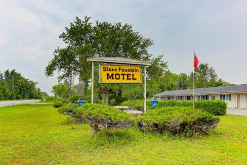 Fenelon FallsStone Fountain Motel的灌木丛中的汽车旅馆标志