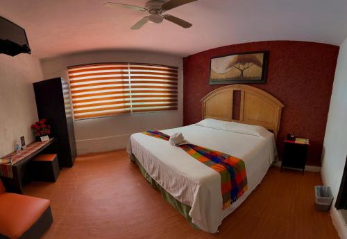 图斯特拉古铁雷斯马卡里奥斯酒店的一间卧室配有一张床和吊扇