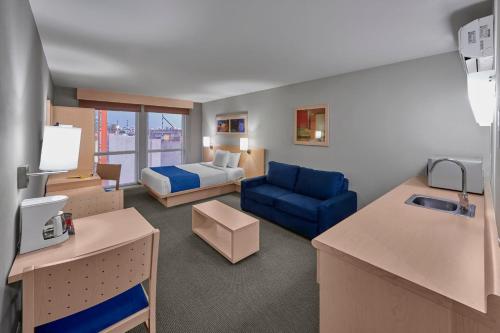 Apizaco阿皮萨科城市快捷酒店的酒店客房,配有床和蓝色的沙发
