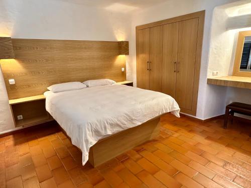卡武埃鲁Villa Valentina的一间卧室配有一张大床和木制床头板