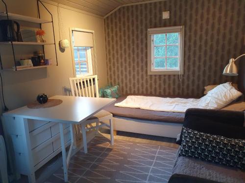 诺尔泰利耶Norrtälje的一间卧室配有一张床、一张桌子和一个窗户。