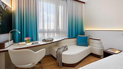 克尔斯特尔巴赫Hey Lou Hotel Frankfurt Airport的酒店客房配有一张床、一张桌子和一把椅子。