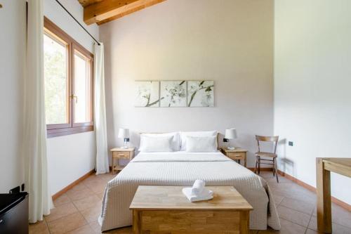 马尔孔艾卡皮尼农庄的白色卧室配有床和桌子
