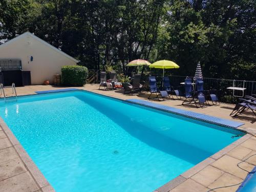 比迪福德Woodside Ash hot tub & pool (sleeps 4-6)的一个带椅子和遮阳伞的大型蓝色游泳池
