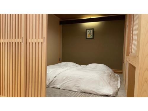 黑部市Unazuki Onsen Sanyanagitei - Vacation STAY 06557v的卧室内的一张带白色床单的床
