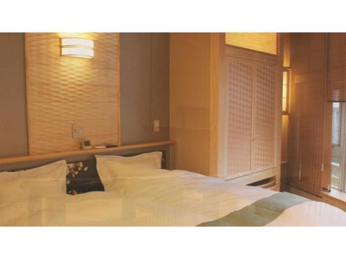 黑部市Unazuki Onsen Sanyanagitei - Vacation STAY 06451v的一间卧室配有一张带白色床单的床和一扇窗户。