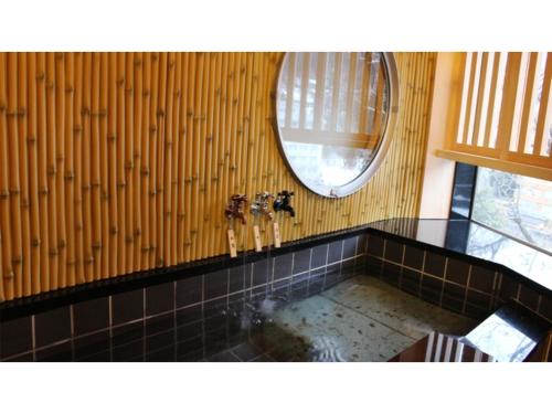 黑部市Unazuki Onsen Sanyanagitei - Vacation STAY 06451v的浴室配有浴缸和墙上的镜子