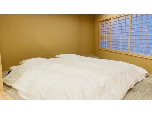 黑部市Unazuki Onsen Sanyanagitei - Vacation STAY 06406v的窗户客房内的一张白色床
