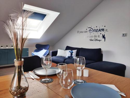 布西圣乔治Akela - Appartement à 12mn de Disneyland Paris !的一张桌子、酒杯和蓝色的沙发