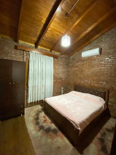 培拉特Vila Mario Berat的一间卧室设有一张床和砖墙