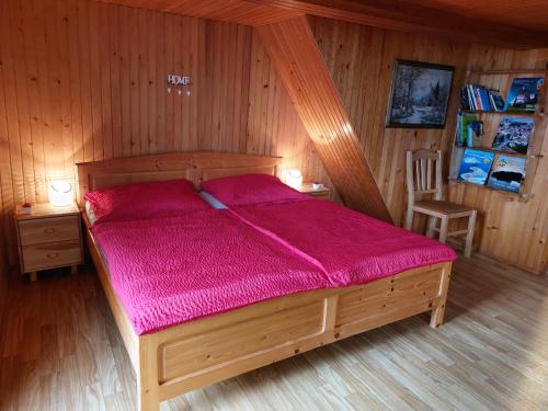 卢斯Počitniška hiška Kašta的一间卧室配有一张带紫色棉被的木床