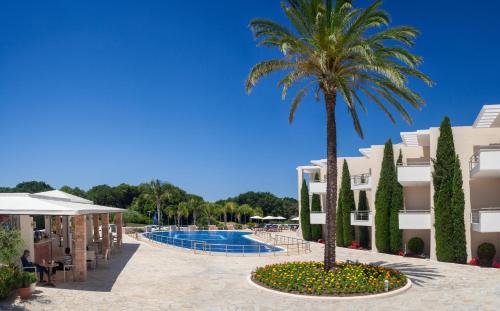 卡纳里奥洛里安西罗克斯尼亚酒店的棕榈树和游泳池的度假村