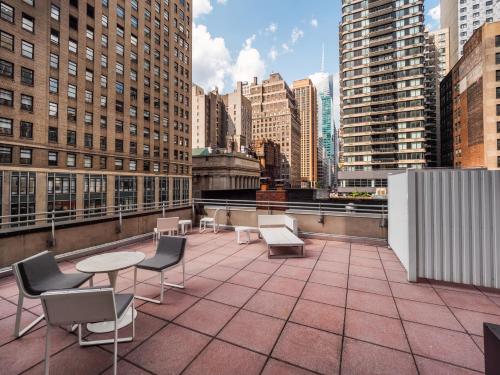 纽约The Herald by LuxUrban的一个带桌椅的屋顶露台,位于大楼内