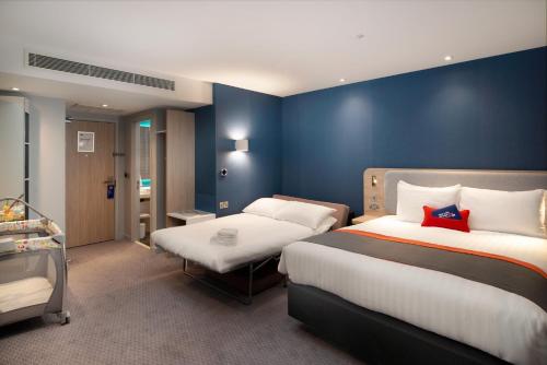 希灵登智选假日酒店 - 伦敦希思罗机场第四航站楼店的一间卧室设有两张床和蓝色的墙壁