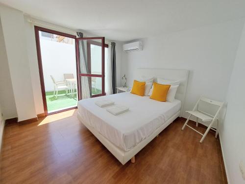 赫雷斯-德拉弗龙特拉雪利中心公寓的卧室配有一张带黄色枕头的大型白色床。