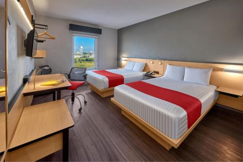 圣路易斯波托西圣路易斯波多西大学区城市快捷酒店的酒店客房配有两张床和一张书桌