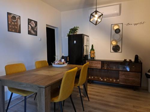 达鲁瓦尔Kuća za odmor Alea Rustica Daruvar的一间带木桌和黄色椅子的用餐室