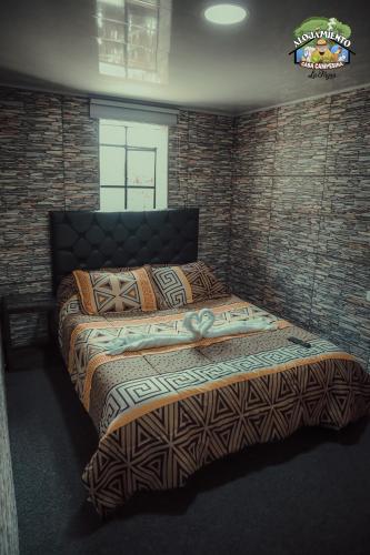 拉卡莱拉Casa Campesina La Fagua的卧室设有一张砖墙内的大床