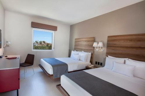 卡波圣卢卡斯City Express Suites by Marriott Cabo San Lucas的酒店客房配有两张床和一张书桌