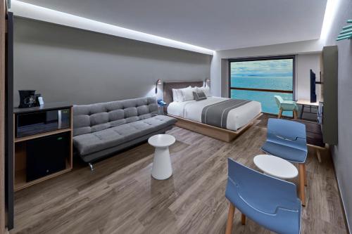 恩塞纳达港City Express Plus by Marriott Ensenada的酒店客房,配有床和沙发