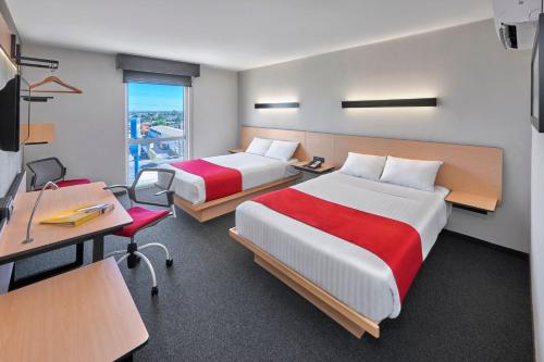 马塔莫罗斯马塔莫罗斯都市快捷酒店的酒店客房配有两张床、一张书桌和一张书桌。