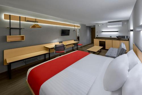 恩塞纳达港City Express by Marriott Ensenada的酒店客房设有一张大床和一张书桌。