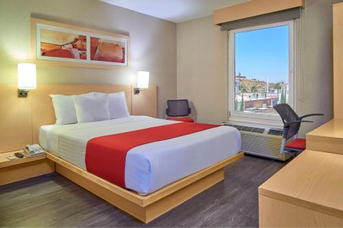 萨卡特卡斯萨卡特卡斯城市快捷酒店的一间设有大床和窗户的酒店客房