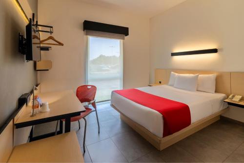 切图马尔切图马尔城市快捷酒店的配有一张床、一张书桌和一扇窗户的酒店客房