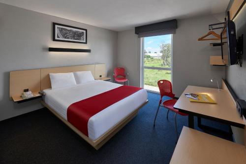 杜兰戈杜兰戈城市快捷酒店的配有一张床、一张书桌和一扇窗户的酒店客房