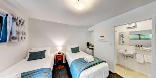 Lochmara Bay洛克马拉旅舍的小型客房配有2张床和水槽。