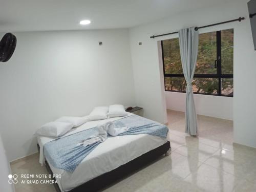 GuadalupeHOTEL SENDERO LAS GACHAS的白色的卧室设有床和窗户