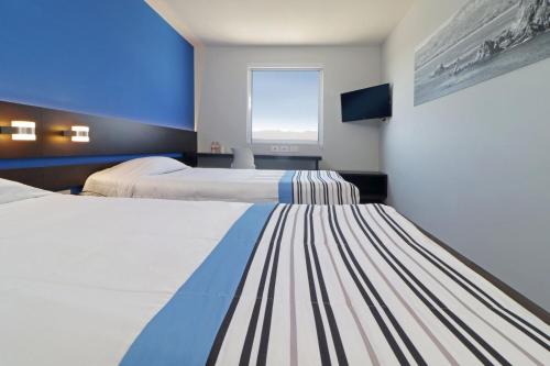 圣路易斯波托西City Express Junior by Marriott San Luis Potosi Zona Industrial的酒店客房设有两张床和窗户。