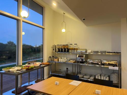 奥克兰Manha Hotel Auckland Airport的厨房配有2张桌子和1个带食物的柜台