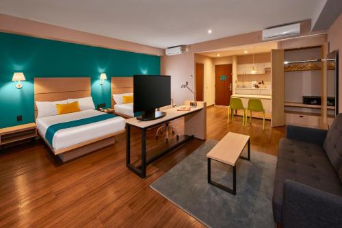 提华纳City Express Suites by Marriott Tijuana Rio的酒店客房设有床和客厅。