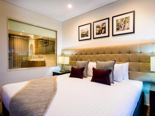 罗斯伯里雅高酿酒度假俱乐部美爵酒店的卧室配有带枕头的大型白色床