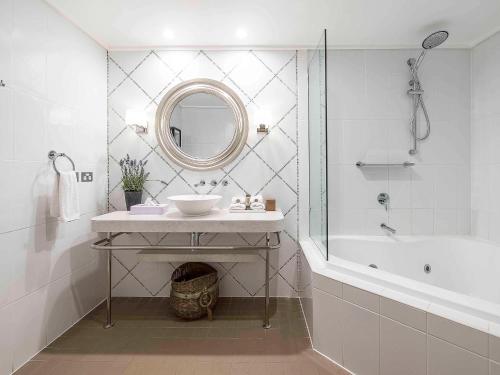 波拉尔帕拉马塔塞鲍勒尔遗址公园公寓式酒店的一间带水槽、浴缸和镜子的浴室