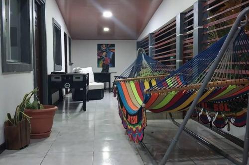 马那瓜Casa Tierra Viva的客厅配有吊床和钢琴