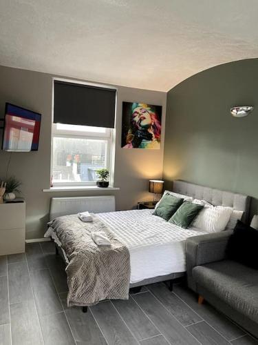 布莱顿霍夫Studio Apartment In Brighton & Hove的一间卧室配有一张床、一张沙发和一个窗口
