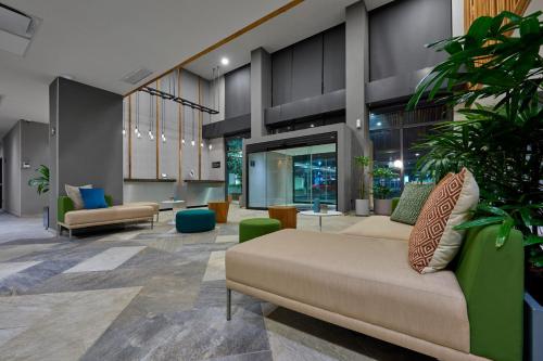 坦皮科City Express Plus by Marriott Tampico的大厅,在大楼里长沙发和植物