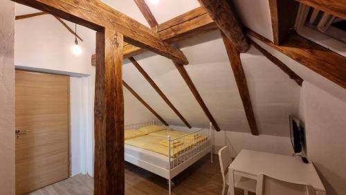 博希尼Apartments Žnidar的小型阁楼卧室配有1张床和1张桌子