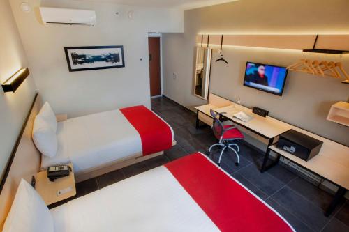 卡波圣卢卡斯City Express Plus by Marriott Cabo San Lucas的酒店客房配有一张床和一张带电脑的书桌
