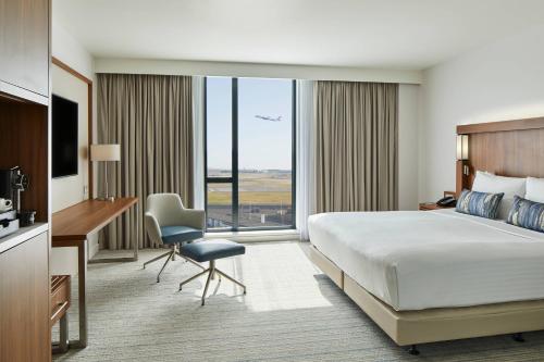 海斯Courtyard by Marriott London Heathrow Airport的配有一张床、一张书桌和一扇窗户的酒店客房